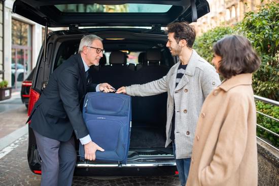 Chauffeur handle luggage of two people after a aiport transfer